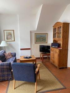 a living room with a couch and a tv at Appartements am Schlossberg in Starnberg