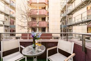a table and chairs on a balcony with a building at Apartament Avignon in Wrocław