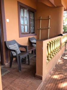 a porch with two chairs and a table and a window at Anjuna Hideout in Anjuna