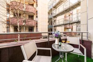 a table and chairs on a balcony with a building at Apartament Avignon in Wrocław
