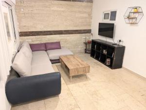 a living room with a couch and a coffee table at Old City Charm in Beer Sheva