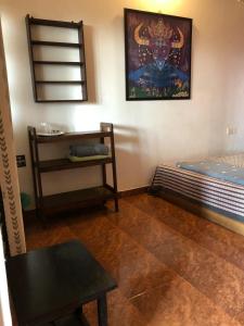 a room with a bed and a table and a chair at Anjuna Hideout in Anjuna