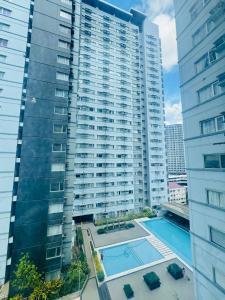 a large apartment building with a swimming pool in front of it at Avida towers davao condo 6thfloor in Davao City