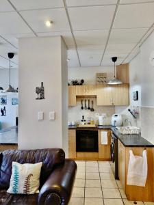 a kitchen with a leather couch in a room at The Tipsy Expat - Paarl - Self Catering Apartment in Paarl