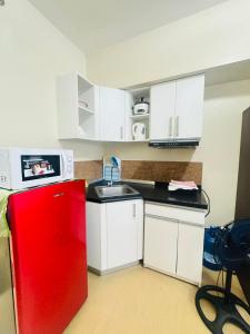 a kitchen with a red refrigerator and white cabinets at Avida towers davao condo 6thfloor in Davao City
