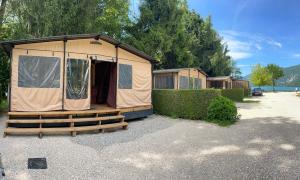 a couple of tents sitting in a parking lot at Camping Onlycamp Les Peupliers in Lepin-le-Lac