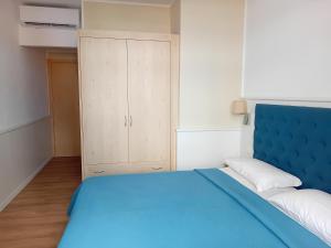 a bedroom with a blue bed and a cabinet at Villa Athena in Giardini Naxos
