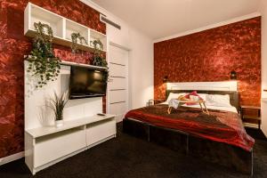 a bedroom with a bed and a red wall at Apartament Avignon in Wrocław