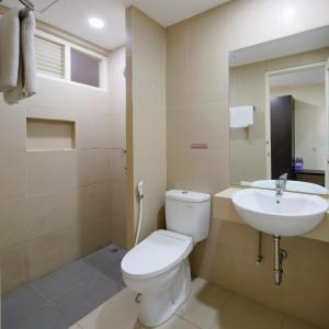 y baño con aseo y lavamanos. en Grand Kebonsari Guesthouse, en Surabaya