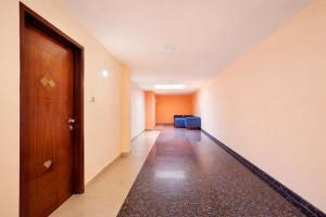 an empty hallway with a door and blue chairs at Balaji Inn in Vellore