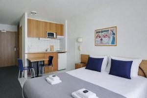 a hotel room with two beds and a kitchen at Les Lilas Serviced Apartments in Les Lilas