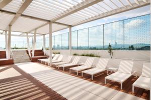 a room with white chairs and large windows at A by Adina Vienna in Vienna