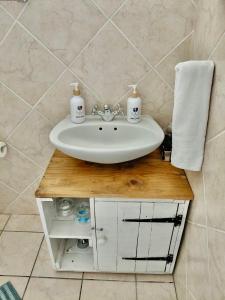 a bathroom with a sink on a wooden table at The Tipsy Expat - Paarl - Self Catering Apartment in Paarl +116 photos