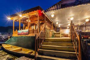 a house with stairs and a boat on the water at White blossom in Srinagar