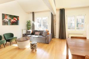 a living room with a couch and a table at Les Lilas Serviced Apartments in Les Lilas