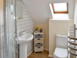 a bathroom with a sink and a toilet at Puffin Cottage in Wroxham +8 photos