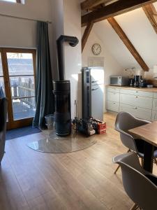 a kitchen with a refrigerator and a table with chairs at Appartements am Schlossberg in Starnberg