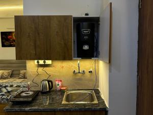 a kitchen counter with a sink and a paper towel dispenser at Premium Studio Appartment in Māripat