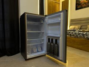 an open refrigerator with bottles of wine in it at Premium Studio Appartment in Māripat