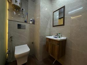 a bathroom with a toilet and a sink and a mirror at Premium Studio Appartment in Māripat