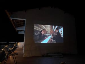 a tv screen with two men sitting at a bar at Nhà Vườn - Garden homes in Ấp Bến Ké (2)