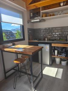 a kitchen with a wooden table and a window at Patagonia Tiny house 3 in El Chalten