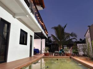 a house with a swimming pool in the yard at Nhà Vườn - Garden homes in Ấp Bến Ké (2)