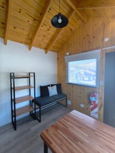 a living room with a bench and a projection screen at Patagonia Tiny house 3 in El Chalten