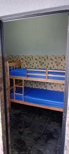 a bunk bed with blue sheets in a room at Casa para agrishow in Ribeirão Preto