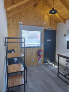 a room with a ladder and a door and a table at Patagonia Tiny house 3 in El Chalten +6 photos