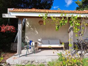 a pergola with a couch sitting on a patio at House on the hill, near Aubeterre-sur-dronne in Saint-Romain