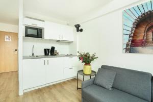 a living room with a couch and a kitchen at Les Lilas Serviced Apartments in Les Lilas