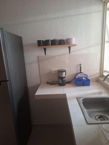 a small kitchen with a sink and a coffee maker at Comfortable and nice house in Caucel in Mérida