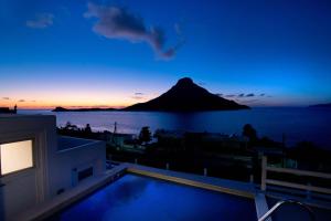 a view of the ocean and a mountain at sunset at Villa Katerina - Between sea & mountain in Kalymnos +48 photos