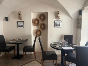a restaurant with two tables and chairs and baskets on the wall at Hôtel CASITA in Puygiron