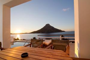 a table and chairs on a balcony with a mountain at Villa Katerina - Between sea & mountain in Kalymnos