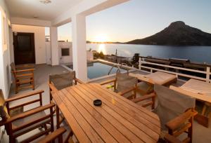 a deck with a wooden table and chairs and the ocean at Villa Katerina - Between sea & mountain in Kalymnos