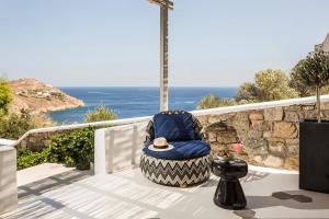 a blue chair sitting on a patio with the ocean at LYO II Boutique Suites in Mikonos