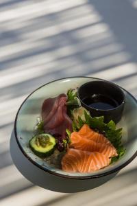 a plate of food with fish and vegetables on a table at LYO II Boutique Suites in Mikonos +85 photos