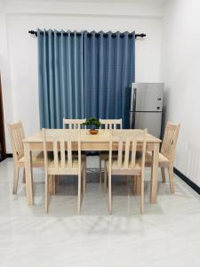 a dining room table with chairs and a refrigerator at Golden Breeze Mirissa in Kamburugamuwa
