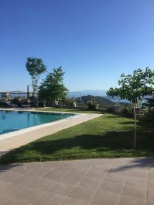 a walkway next to a yard with a swimming pool at VILLA KTIMA MELINA Pelio ΒΙΛΑ ΜΕ ΠΙΣΙΝΑ ΒΟΛΟΣ ΠΗΛΙΟ in Álli Meriá