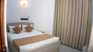 a hotel room with a bed with pillows at Golden Breeze Mirissa in Kamburugamuwa