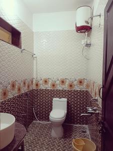 a bathroom with a toilet and a sink at Tunga Vilasa in Tīrthahalli +18 photos