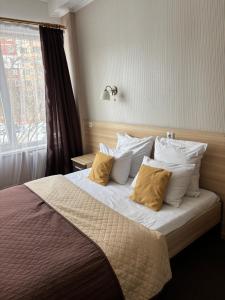 a bedroom with a bed with white pillows and a window at Hostel Iskra in Lviv