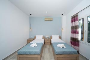 a room with two beds and a window at Porto Blue Heaven in Porto Rafti +19 photos