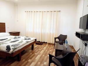 a bedroom with a bed and a television in it at Tunga Vilasa in Tīrthahalli