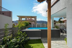 a backyard with a swimming pool and a house at Porto Blue Heaven in Porto Rafti