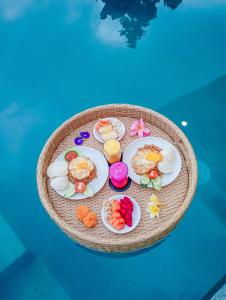 a table with plates of food on top of a pool at Umah Geina Ubud in Tegalalang
