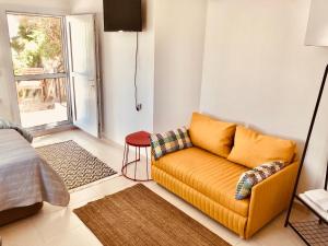 a living room with a yellow couch and a window at Small House in Bodrum in Milas