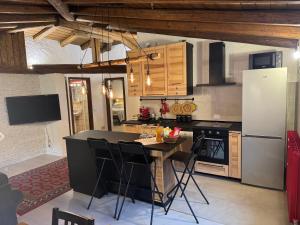 a kitchen with a table and a refrigerator at Mansarda al Noce in Pellizzano